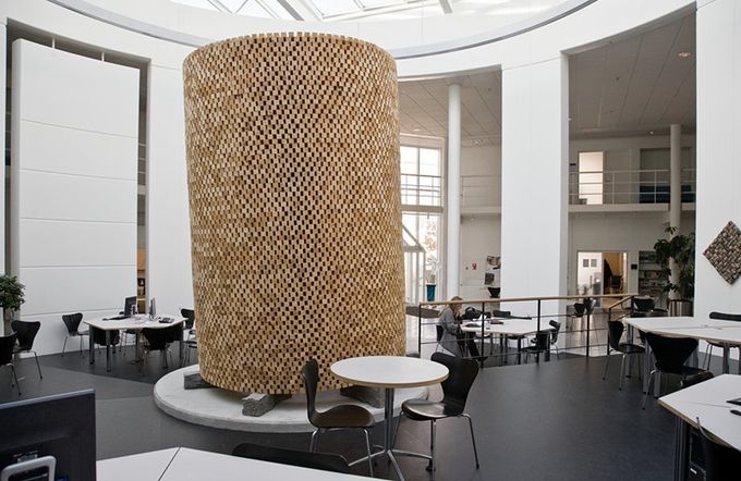 Cylindrisk skulptur af træ på granitblokke. Designcenter TEKO i Herning.